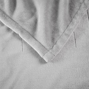 Close up of grey plush fleece blanket texture with stitched hem