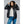Woman wearing a black 8K FlexWarm hooded puffer jacket over a grey sweater and blue jeans