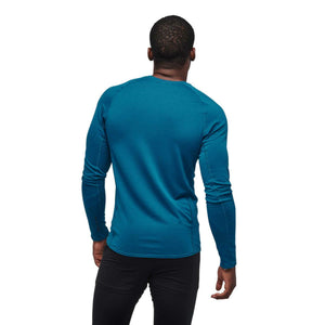 Back view of a person wearing a blue Black Diamond long sleeve base layer shirt
