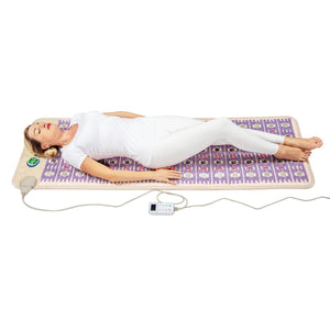 Person lying on a HealthyLine infrared therapy mat with a digital controller